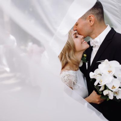 groom-black-tuxedo-hugs-tender-stunning-bride-while-they-stand